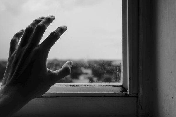 close up photography of hand near window