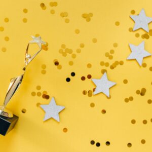 golden statuette and stars on yellow background